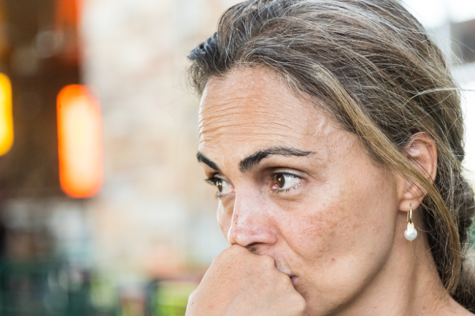 Mulher de meia idade pensativa, representando mudanças corporais e gordura abdominal na menopausa